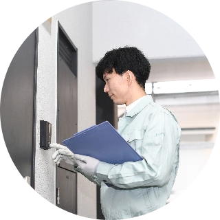 インターフォンを押す業者の写真